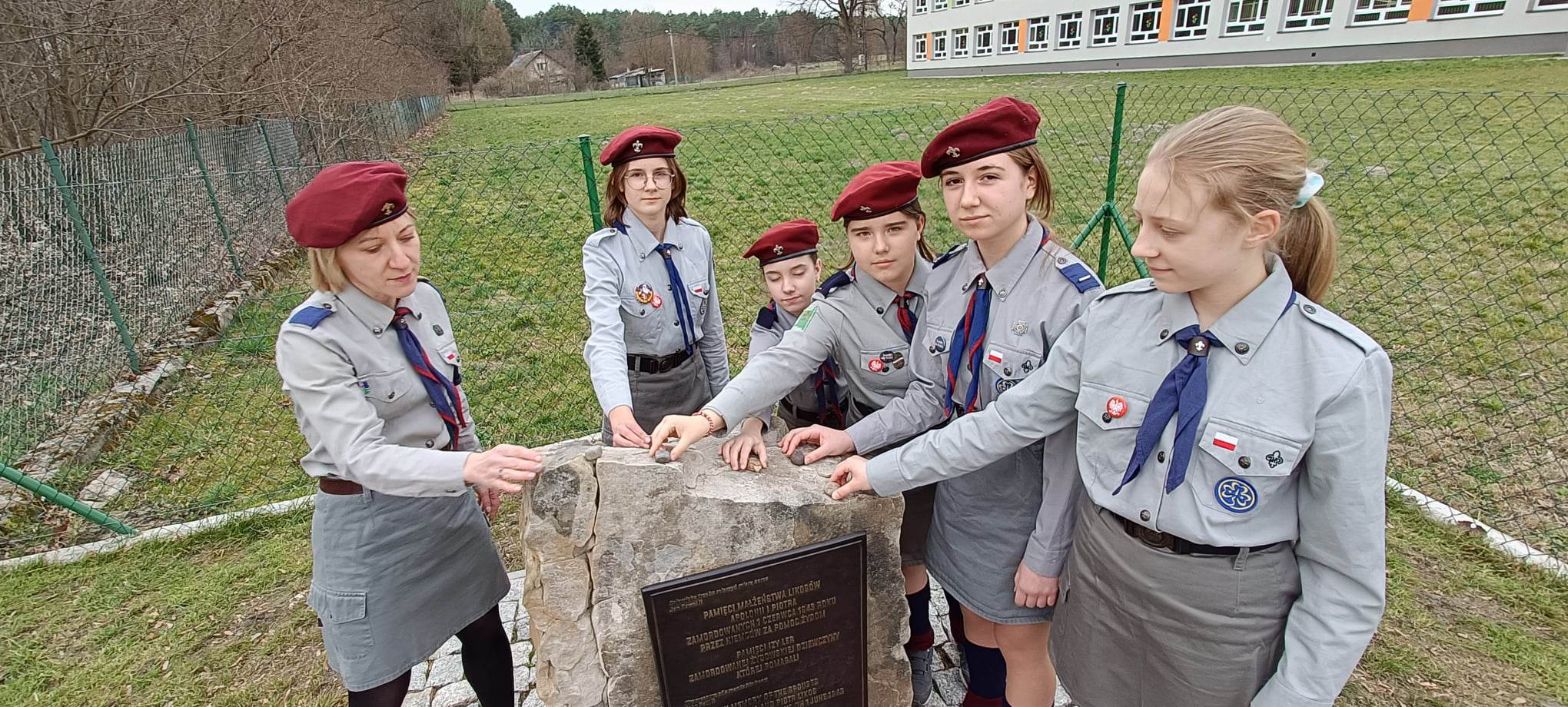Harcerki kładą kamyki na pomniku z tablicą upamiętniającą Polaków ratujących Żydów pod okupacją niemiecką w Opoce Dużej